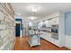 Well-lit kitchen with white cabinets, stainless steel appliances, kitchen island, and unique stone wall at 2016 Colt Rd, Indianapolis, IN 46227