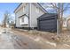 View of a house and detached garage with gray siding and updated windows at 218 W 31St St, Indianapolis, IN 46208