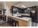 Modern kitchen featuring sleek black cabinetry, quartz countertops, and a stylish breakfast bar with seating at 362 1400 N, Summitville, IN 46070