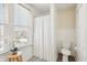 Bathroom featuring vintage radiator, neutral paint, toilet, large window, and shower curtain for privacy at 403 S Ohio St, Sheridan, IN 46069