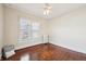Bright bedroom featuring hardwood floors, a ceiling fan, and a window with decorative curtains at 403 S Ohio St, Sheridan, IN 46069