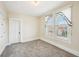 Cozy carpeted bedroom featuring a window with sheer curtains and a classic paneled door at 403 S Ohio St, Sheridan, IN 46069