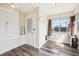 Entryway featuring wood-look floors, coat rack, charming door with lace curtain, and storage at 403 S Ohio St, Sheridan, IN 46069
