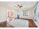 Bright living room featuring hardwood floors, a ceiling fan, and stylish curtains at 403 S Ohio St, Sheridan, IN 46069