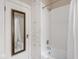 Clean bathroom features a tub with shower, built-in storage, and a mirrored cabinet at 4220 Sunset Ave, Indianapolis, IN 46208