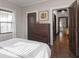 Cozy bedroom features a white comforter, dark wood floors, and natural light from the window at 4220 Sunset Ave, Indianapolis, IN 46208