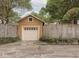 A detached garage featuring a single door, traditional wood siding, and natural foliage around the base at 4220 Sunset Ave, Indianapolis, IN 46208