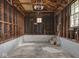 Interior view of garage featuring unfinished walls, open ceiling with rafters, and concrete floor at 4220 Sunset Ave, Indianapolis, IN 46208