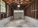 Interior view of garage featuring unfinished walls, open ceiling with rafters, and concrete floor at 4220 Sunset Ave, Indianapolis, IN 46208