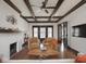 Bright living room features hardwood floors, exposed beam ceiling, and a cozy brick fireplace at 4220 Sunset Ave, Indianapolis, IN 46208