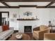 Bright living room features hardwood floors, exposed beam ceiling, and a cozy brick fireplace at 4220 Sunset Ave, Indianapolis, IN 46208