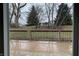 View from sliding glass doors to wooden back deck and large backyard with trees at 5746 Overcrest Dr, Indianapolis, IN 46237
