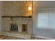 Living room stone fireplace is focal point with lamp and window blinds; hardwood floors present at 5746 Overcrest Dr, Indianapolis, IN 46237