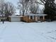 Charming single-story brick home with attached garage surrounded by snow-covered yard and bare trees at 10229 Baribeau Ln, Indianapolis, IN 46229