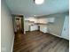 Eat-in kitchen with white cabinets, white appliances, neutral paint, and new dark brown flooring at 10229 Baribeau Ln, Indianapolis, IN 46229
