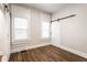 Bright bedroom featuring white trim, wood-look floors, and a sliding barn door closet at 1133 Olive St, Indianapolis, IN 46203