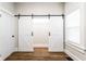 Bright bedroom features white trim, wood-look floors, and a sliding barn door closet at 1133 Olive St, Indianapolis, IN 46203