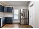 Kitchen featuring shaker cabinets, stainless steel fridge, white countertops, and wood-look flooring at 1133 Olive St, Indianapolis, IN 46203