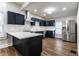 Bright kitchen features shaker cabinets, stainless steel appliances, white countertops, and wood-look flooring at 1133 Olive St, Indianapolis, IN 46203
