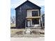 Modern two-story home featuring black siding, large windows, and a covered porch, in a construction phase at 1523 N Beville Ave, Indianapolis, IN 46201