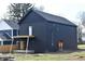 View of the home's back facade featuring a deck and stylish dark siding, enhancing outdoor living appeal at 1523 N Beville Ave, Indianapolis, IN 46201