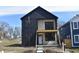 Two-story home with black siding, large windows, and a covered porch, surrounded by a well-lit neighborhood at 1523 N Beville Ave, Indianapolis, IN 46201