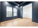 Contemporary living room featuring beautiful floors, natural light from windows, and dark blue accent wall at 20017 Old Dock Rd, Westfield, IN 46074