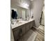 Bathroom featuring double sinks, a large mirror, storage cabinets, and a walk-in shower at 253 Darrough Dr, Greenwood, IN 46143