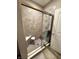 Tiled bathroom shower featuring a built-in seat, handrails, and a glass door at 253 Darrough Dr, Greenwood, IN 46143