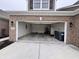 Open garage with brick accents, a concrete driveway, space for two cars, and built-in storage at 253 Darrough Dr, Greenwood, IN 46143