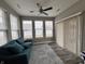 Bright sunroom features a ceiling fan, multiple windows, wood-look flooring, and access to the outdoors at 253 Darrough Dr, Greenwood, IN 46143