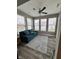 Bright sunroom features a ceiling fan, multiple windows, wood-look flooring, and a comfortable blue sofa at 253 Darrough Dr, Greenwood, IN 46143