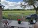 Outdoor deck with grill, table, and chairs overlooking a grassy field at 2650 W State Road 252, Flat Rock, IN 47234