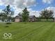 Exterior shot of brick home with attached garage and spacious lawn and garden at 2650 W State Road 252, Flat Rock, IN 47234
