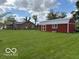 Home's exterior with spacious lawn and red barn in the background at 2650 W State Road 252, Flat Rock, IN 47234