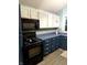 Updated kitchen featuring black appliances and custom cabinetry at 2650 W State Road 252, Flat Rock, IN 47234