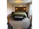 Main bedroom featuring a wooden headboard, bedside tables, an ottoman, and hardwood floors at 2650 W State Road 252, Flat Rock, IN 47234