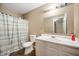 Bathroom featuring light striped shower curtain, vanity, toilet, tile floor and modern lighting at 411 Red Tail Ln, Indianapolis, IN 46241