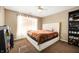 Bedroom featuring plush queen bed, storage shelves, ceiling fan, and window with blinds at 411 Red Tail Ln, Indianapolis, IN 46241