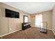 Bedroom with dark dresser, tv, window with sheer curtains and exercise machine at 411 Red Tail Ln, Indianapolis, IN 46241