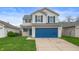 Charming two-story home with blue accents, attached two car garage and inviting curb appeal at 411 Red Tail Ln, Indianapolis, IN 46241