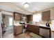 Traditional kitchen with dark cabinets, stainless steel appliances, and wood-look flooring at 411 Red Tail Ln, Indianapolis, IN 46241