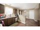 Kitchen area showcasing brown cabinets, a stainless steel dishwasher, and views into the dining area at 411 Red Tail Ln, Indianapolis, IN 46241