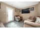 Comfortable living room with carpet, chairs, couches, mounted television and access door at 411 Red Tail Ln, Indianapolis, IN 46241