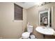 Compact powder room with a white toilet, pedestal sink, and window with blinds for privacy at 411 Red Tail Ln, Indianapolis, IN 46241