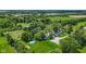 Aerial view of an expansive green lawn featuring an above-ground pool surrounded by lush trees and a gravel drive at 4131 N County Road 500 E, Danville, IN 46122