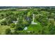 Aerial view of expansive property featuring an above-ground pool nestled among lush greenery and a long gravel driveway at 4131 N County Road 500 E, Danville, IN 46122