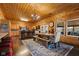 A dining room features wood-paneled walls, a chandelier, a dining table, and an adjacent kitchen with counter seating at 4131 N County Road 500 E, Danville, IN 46122