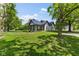 Charming two-story home with black metal roof and covered porch nestled on a lush green lawn at 4131 N County Road 500 E, Danville, IN 46122