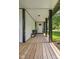 Inviting front porch with wood flooring, bench seating and plants framing the front door at 4131 N County Road 500 E, Danville, IN 46122